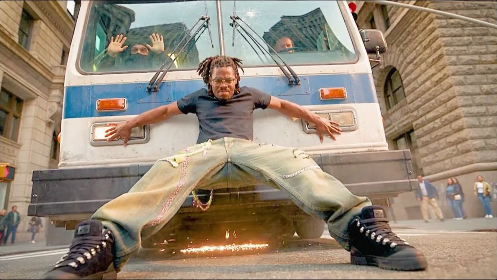 The hero braced against the front of a bus, boots throwing sparks as he stops it dead in the street